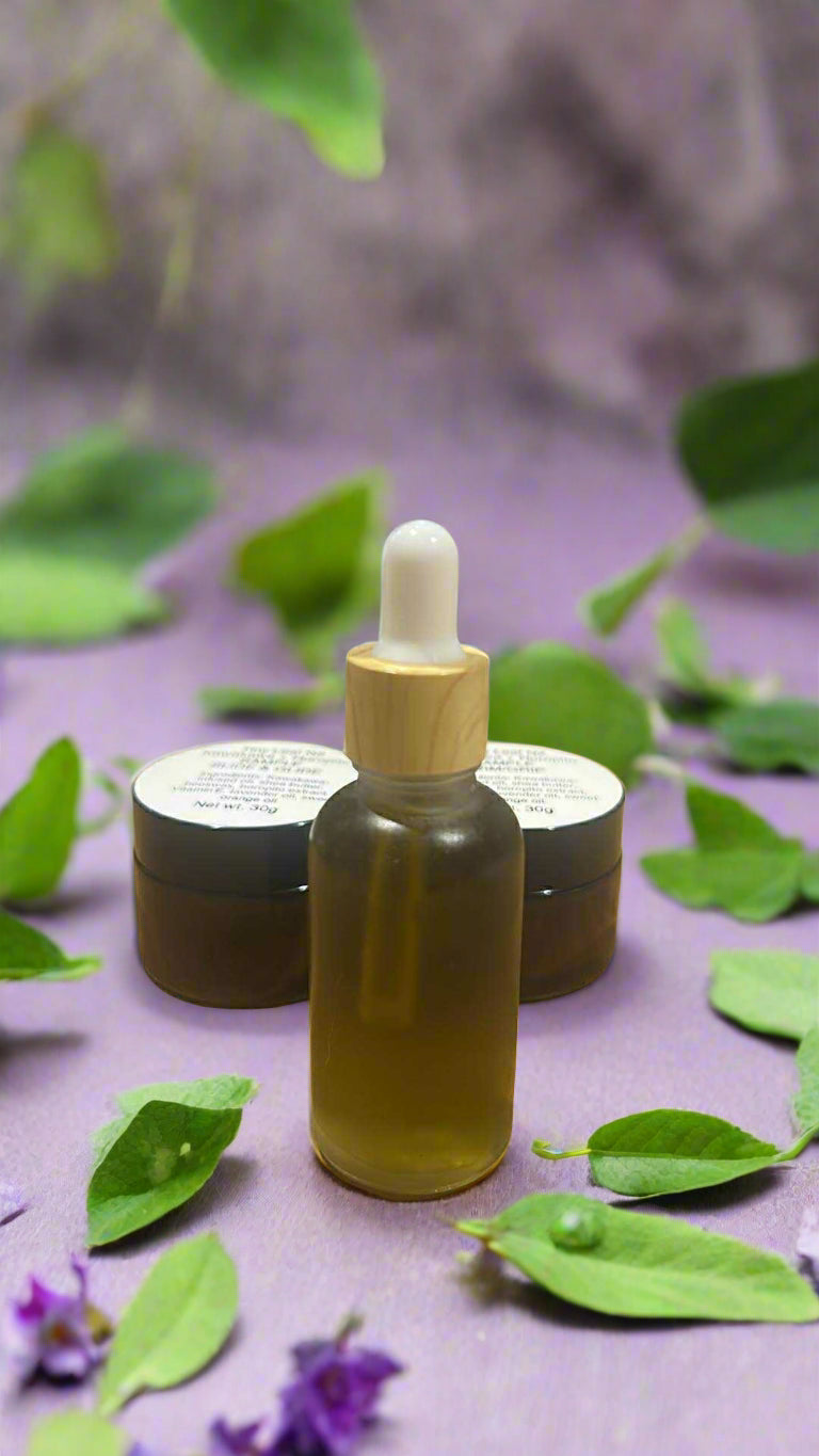 Glass dropper bottle with wooden cap on a wooden surface with two small containers in the background.