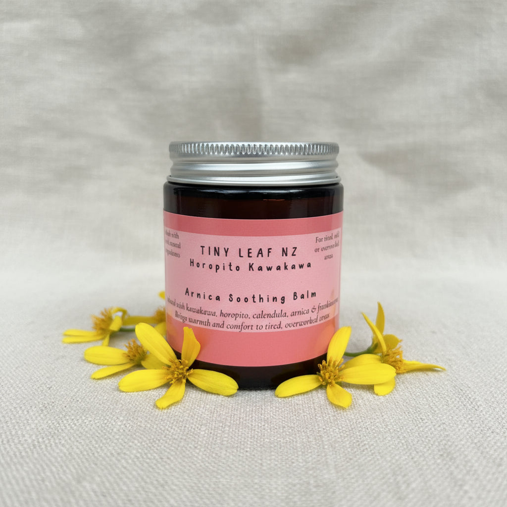 Jar of Tiny Leaf NZ Arnica Soothing Balm on a linen surface with a blurred background