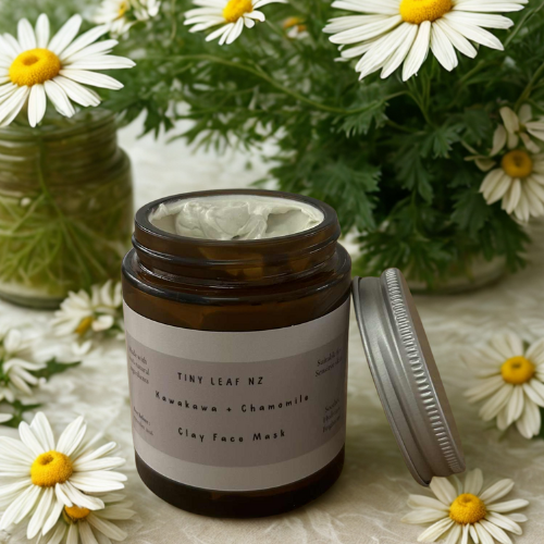 Jar of clay face mask with daisies in the background