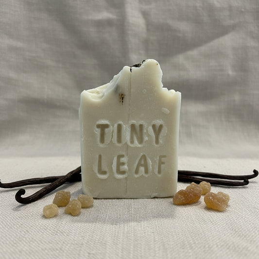 Bar of soap with 'TINY LEAF' text on a cardboard surface