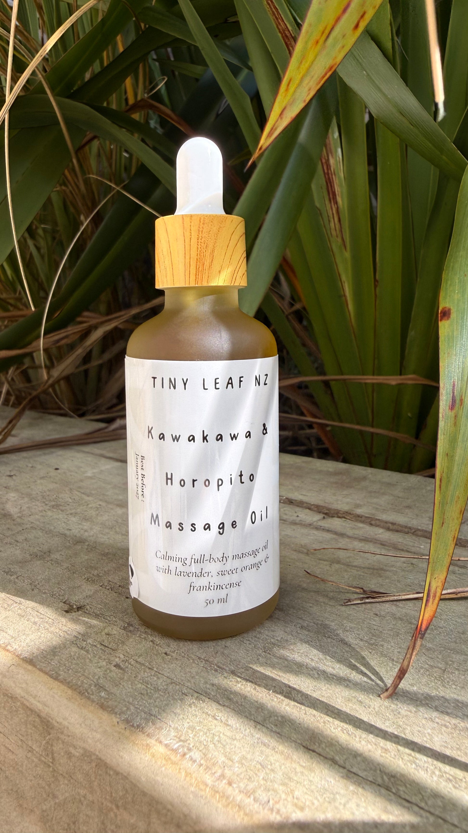 Tiny Leaf NZ Kawakawa and Horopito massage oil in glass bottle with wooden lid, natural botanical body oil for relaxation