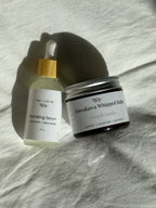 Hydrating Serum and Kawakawa Whipped Balm on a textured surface