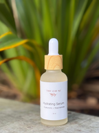 Hydrating serum bottle with dropper on a stone surface with greenery in the background