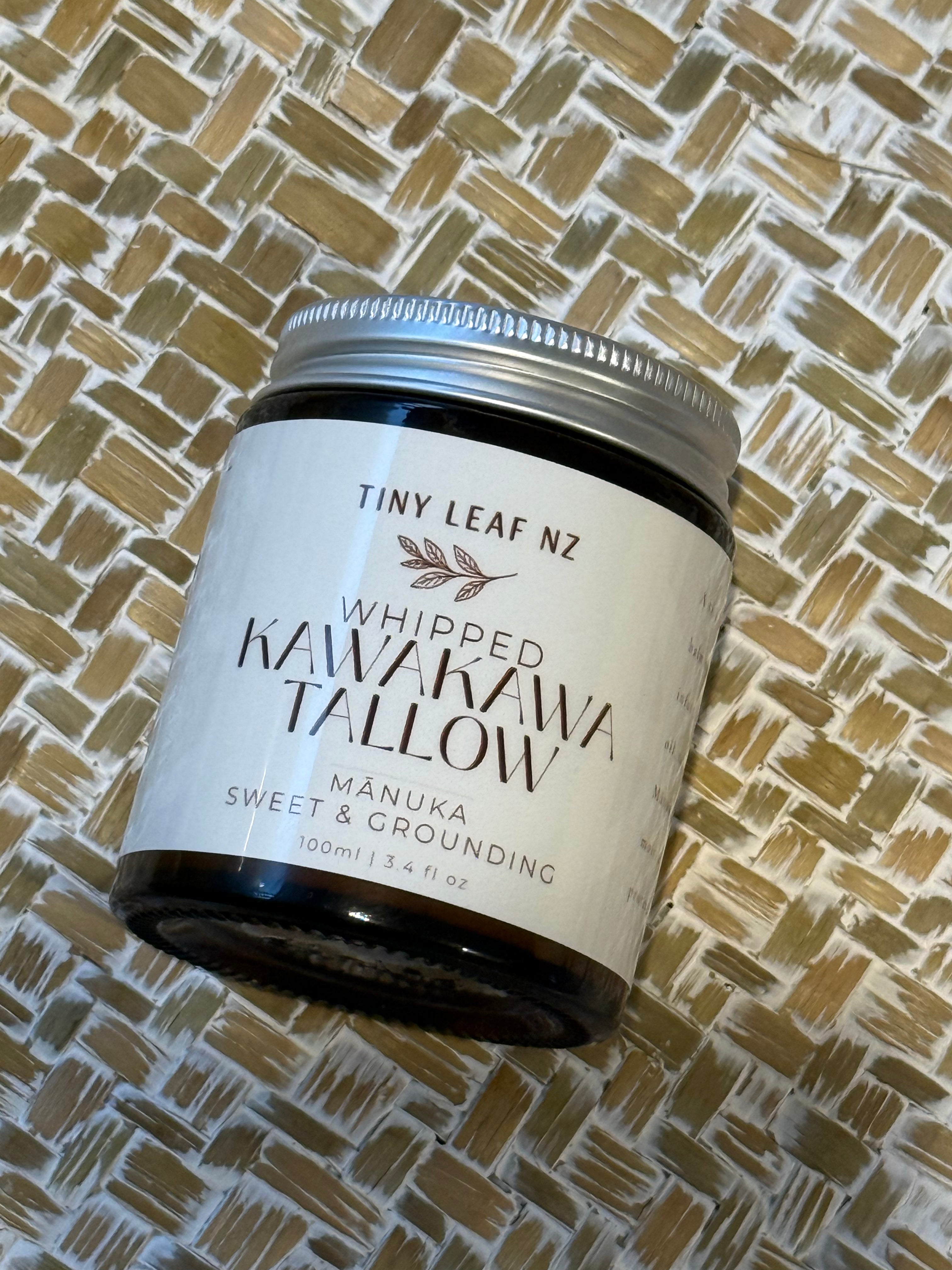 A jar of Tiny Leaf NZ Whipped Kawakawa Tallow on a textured woven mat background.