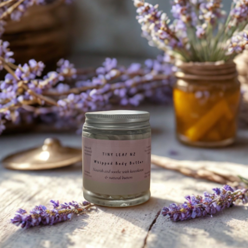 Jar of whipped body butter with lavender flowers on a wooden surface