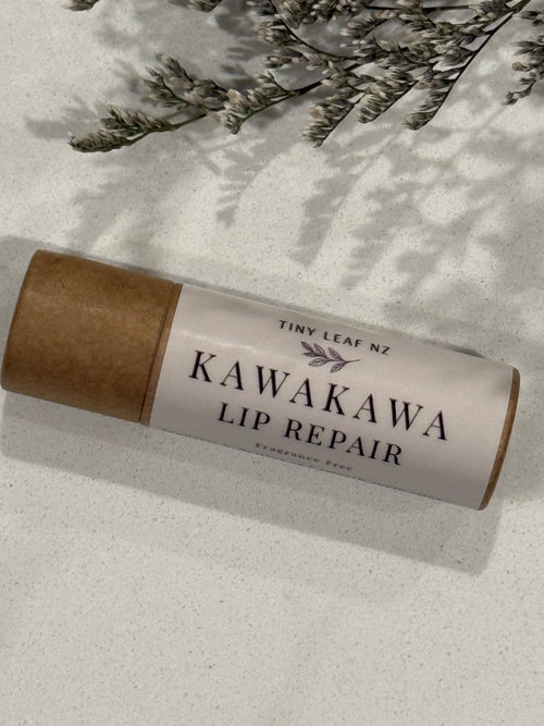 Kawakawa lip repair stick with brown paper wrap on a light surface