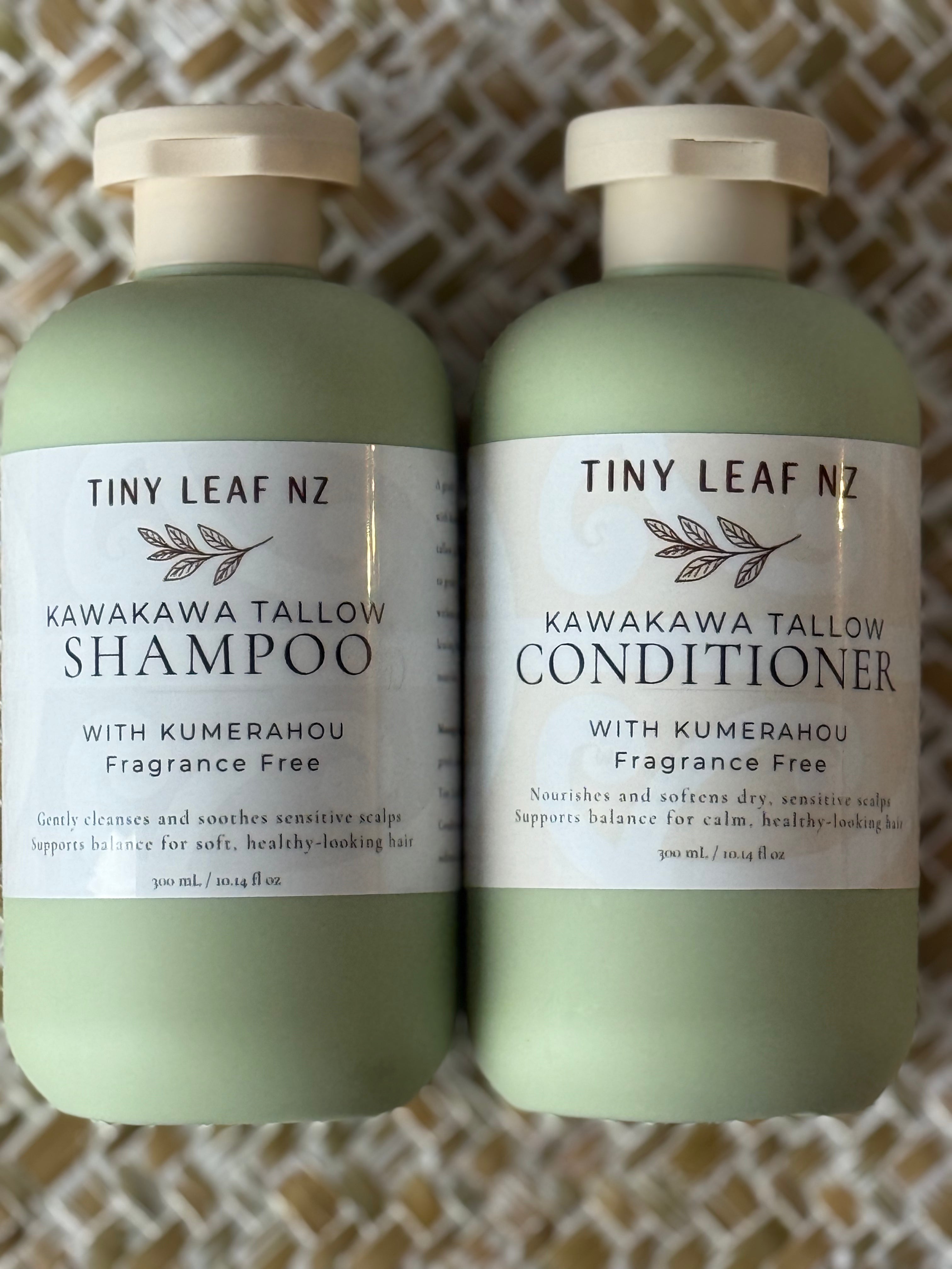 Two pale sage green bottles of Tiny Leaf Nz hair care products, labeled Kawakawa Tallow Shampoo and Kawakawa Tallow Conditioner, placed side by side on a woven beige and white mat.