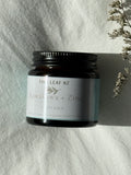 Tin of Tiny leaf NZ balm on a textured white surface with dried flowers.
