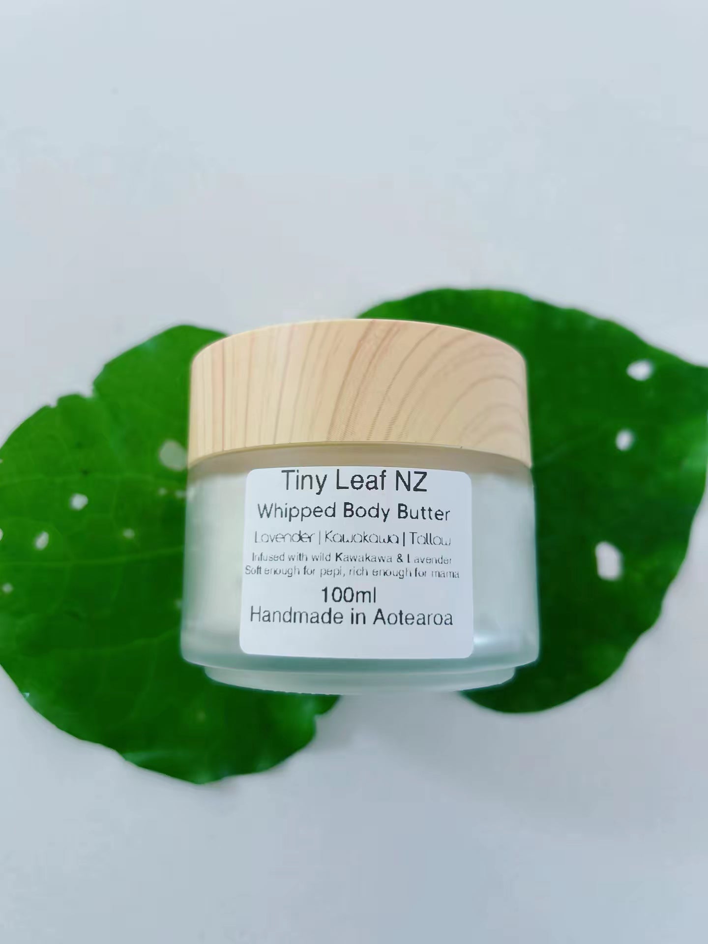 Jar of Tiny Leaf NZ Kawakawa Tallow Whipped Body Butter on a light background with green leaves