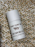 A white roll-on deodorant bottle labeled 'TINY LEAF NZ DEODORANT PURE & SENSITIVE' placed diagonally on a woven straw mat background.