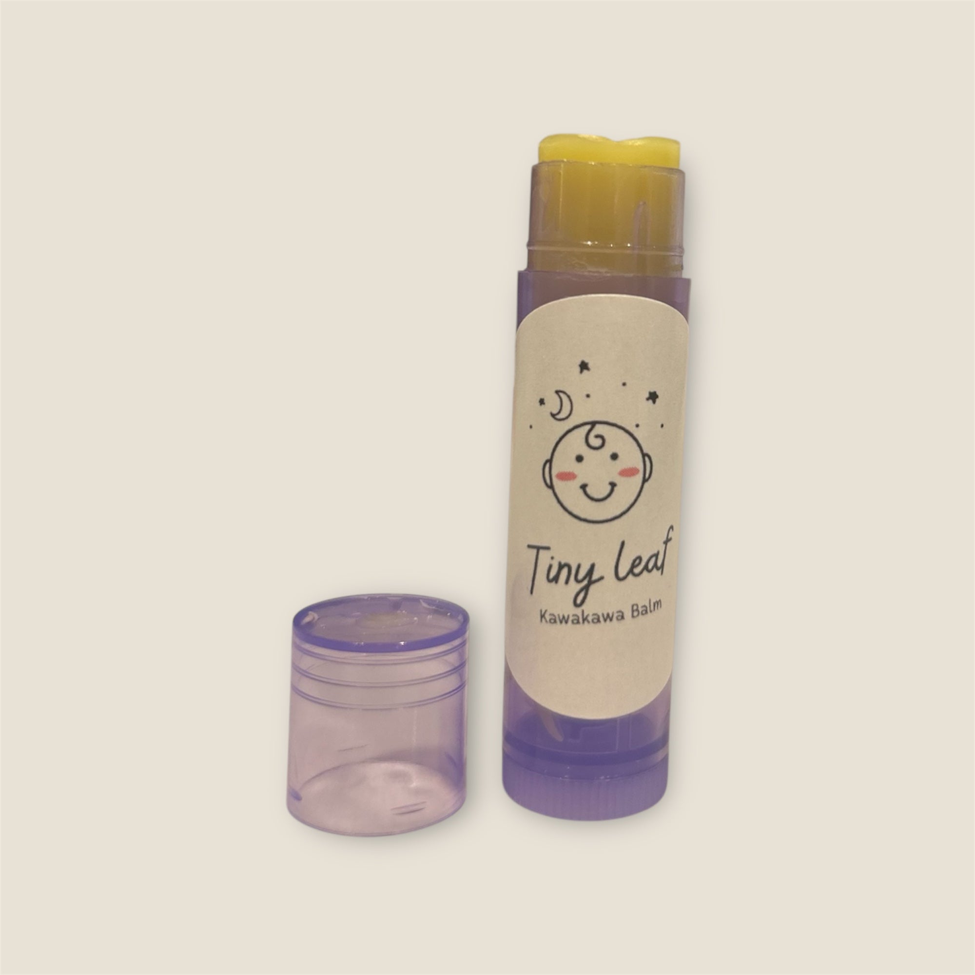Lip balm with 'Tiny Leaf' branding on a beige background
