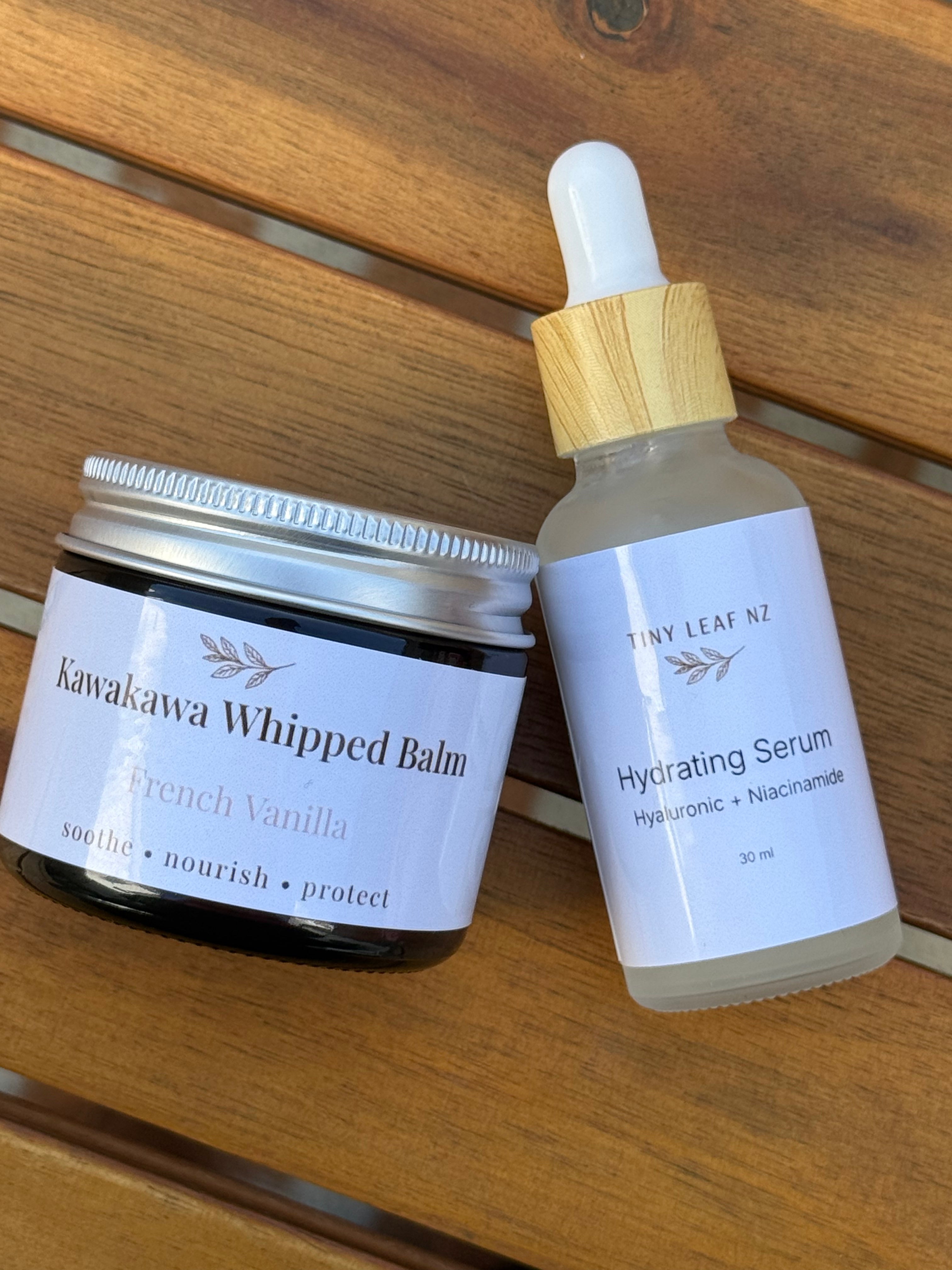 Kawakawa Whipped Balm and Hydrating Serum on a wooden surface