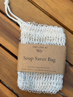 White soap saver bag with a brown label on a wooden surface