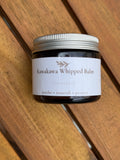 Jar of Kawakawa Whipped Balm on a wooden surface