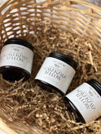Three small jars of Tiny Leaf NZ Whipped Kawakawa tallow balm arranged in a woven basket with shredded paper filler.