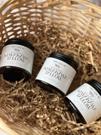 Three small jars of whipped kawaka yellow from Tiny Leaf NZ, arranged in a woven basket filled with brown paper shred.