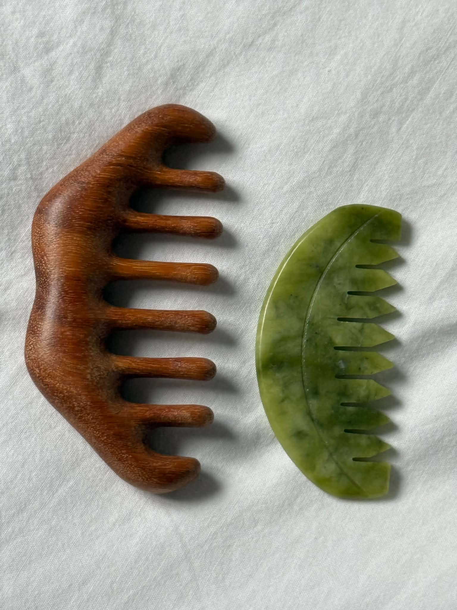 Wooden and green stone comb on a white background