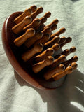 Wooden hairbrush on a light fabric background
